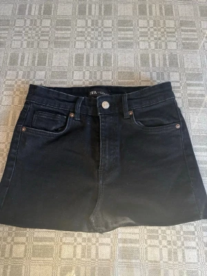 Kort jeanskjol - Kort svart jeanskjol från Zara, det står att den är i storlek 36 men skulle säga att den passar folk som har xxs-xs