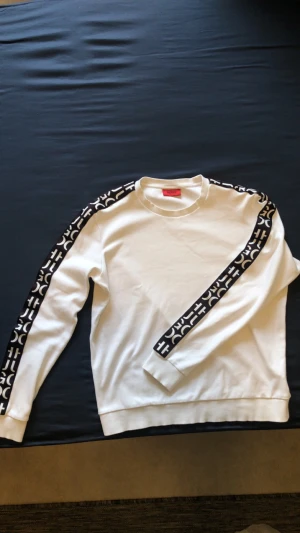 Hugo Boss - Vit sweatshirt från Hugo med logoband längs ärmarna, mycket bra skick, storlek M.
