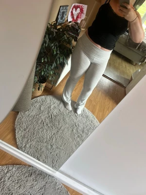 Ljusgrå mjukisbyxor med hög midja - Supersköna ljusgrå mjukisbyxor med hög midja och raka ben. Byxorna har en enkel och clean look utan synliga loggor eller detaljer. Perfekta för chill dagar hemma eller när du vill vara bekväm. Materialet känns mjukt och stretchigt.