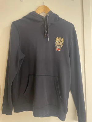 Mörkblå hoodie från Morris - Hej, Säljer en fin mörkblå hoodie från Morris med huva. Storlek M skick 8/10 inga defekter vid funderingar hör gärna av dig 👍🏼😊