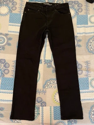 Svarta jeans från Hampton Republic - Svarta raka jeans från Hampton Republic med klassisk femficksdesign och normal midja. Jeansen har bälteshällor och knappgylf. Perfekta för en stilren och enkel look.