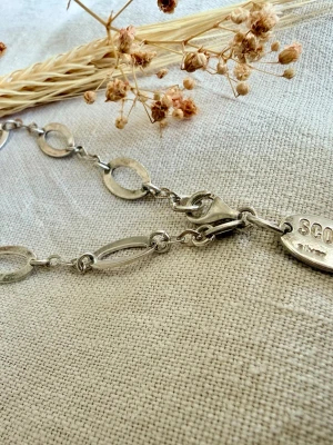 Silverfärgat armband med ovala länkar - Stilrent armband i silver med både runda och ovala länkar. Har en bricka med texten 'SCOOP' och 'silver 925'. Perfekt accessoar för dig som gillar minimalistiska smycken med en unik touch.