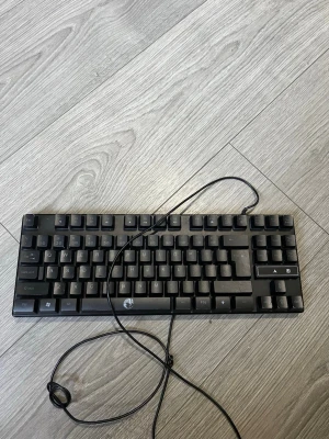 Svart kompakt tangentbord USB - Säljer ett svart kompakt tangentbord med USB-kabel. Tangentbordet har en klassisk layout med svenska tecken och låg profil, perfekt för gaming eller arbete vid datorn. Passar till både laptop och stationär dator.