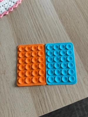 Orange blå Octopus Mobilhållare sugpropp silikon - 2 pack Silikon hållare till mobilen. Med 24st sugkoppar och klister på baksidan.  Färgerna på min profil går att blanda hur man vill, meddela om du vill ha annan färg vid köp.   Skickar gärna i bundle. Mått cirka 5,5 x 8 cm.     #silikon #mobilhållare #octopus #octoholder #case #iphone #idealofsweden #skal #tillbehör #octopushållare #stativ #tiktok #mobilgrepp #sugpropp #silikongrepp #popsockets 