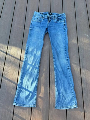 Blå bootcut jeans från LTB low waist - Säljer ett par blå bootcut jeans från LTB, modell Valerie. Jeansen har klassisk femficksdesign, normal midja och lätt slitna detaljer. Perfekta för dig som gillar en avslappnad men ändå snygg stil.