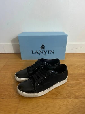 Lanvin Cap Toe - Säljer ett fett par mörkblåa lanvins som är storlek 42-43. Fick skorna i julklapp, har använd de några gånger sedan dess. Box och tillbehör medföljer. Skickar även med ett par nya skosknören då de originala är ganska slitna. Skriv vid mista lilla fråga eller fundering!