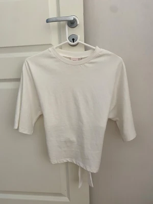 Vit croppad topp med knyt i ryggen - Super fin Nelly tröja med knyte i ryggen storlek Xs knappt använd💗