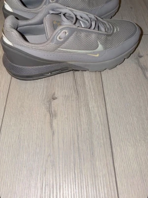 Nike Air Max grå sneakers - Snygga grå Nike Air Max sneakers med mesh- och syntetmaterial. Skorna har en låg siluett, klassisk vit swoosh på sidan och synlig Air Max-dämpning i sulan. Perfekta för dig som gillar sportig och clean stil. Använda 1 gång.
