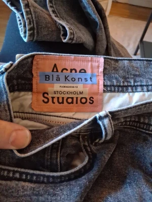 Grå jeans från Acne Studios Blå Konst - Snygga grå jeans från Acne Studios Blå Konst med klassisk femficksmodell och dragkedja från YKK. Jeansen har en tvättad look och är tillverkade i ett robust denimtyg. Perfekta för dig som gillar stilrena och trendiga plagg.