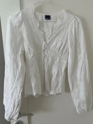Vit broderad blus från Gina Tricot - Intressekoll på min superfina blus från gina tricot, endast använd 1 gång och har inga synliga defekter förutom att den är felsydd med en grön tråd (se bild 3&4) men inget som syns när man har på den🩷upplever att den börjar bli för liten för mig🥹🥹