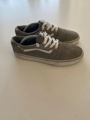 Gråa Vans storlek 37 (passar även 38, 39) - Säljer ett par gråa Vans Old Skool i storlek 37 (stora i storleken och passar även 38, 39). Sneakers med vit sula och klassisk vit sidestripe. Skorna har ovandel i mocka och textil, samt vita skosnören. Perfekta för en avslappnad Grisch eller archive stil.