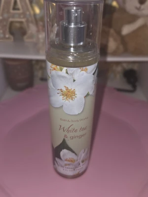 White Tea & Ginger mist Bath & Body Works - Fräsch och blommig body mist från Bath & Body Works med doft av vitt te, ingefära, yuzu, bergamott och geranium. Flaskan är genomskinlig med blommigt motiv och har en praktisk sprayfunktion. Perfekt för dig som gillar lätta och fräscha dofter.