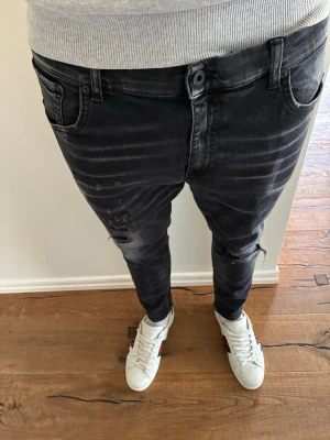 Svarta slim fit jeans från Dondup - Säljer ett par svarta slim fit jeans från Dondup med slitningar. Perfekt till dig som gillar mode. Skicka gärna vid funderingar! Pris kan diskuteras 