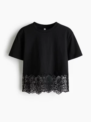 Svart t-shirt med spetsdetalj - Svart t-shirt med korta ärmar och snygg spetskant nertill. Tröjan är från H&M och är slutsåld! Är endast använd en gång. Köpt för 199kr