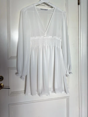 Vit omlottklänning från 157 - Superfin vit kortklänning från 157 med omlott-skärning och smock i midjan. Endast använd en gång under min konfirmation förra året 💕