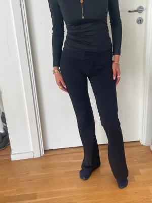 Svarta utsvängda leggings - Snygga svarta leggings med utsvängda ben och hög midja. Stretchigt material som sitter tajt över höfterna och låren. Perfekta för en trendig och bekväm stil.