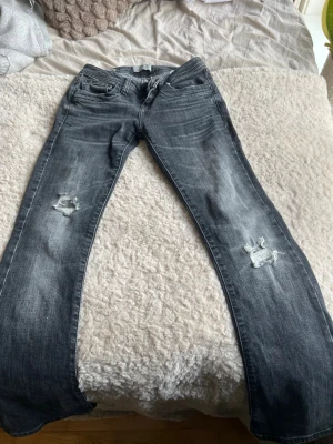 Ltb jeans - Snygga svarta jeans med slitningar på båda benen och utsvängda ben. Jeansen har klassisk femficksdesign och en tvättad look med ljusare partier. Perfekta för en avslappnad och trendig stil.