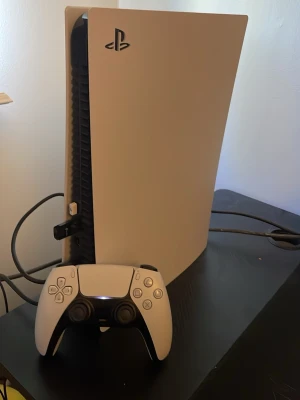 PlayStation 5 med kontroll 750gb storage + gta spel - PlayStation 5 spelkonsol i vit och svart med stilren, futuristisk design. Konsolen är tillverkad i plast och levereras med en matchande trådlös DualSense-kontroll. Perfekt för gaming på nästa nivå med kraftfull prestanda och snygg look.