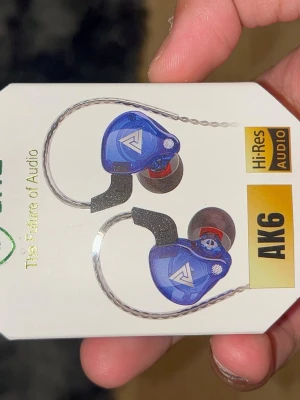 Blå AK6 in-ear hörlurar - Snygga blå in-ear hörlurar från AK6 med transparent design och silverfärgad kabel. Hörlurarna har ergonomisk form och utbytbara silikontoppar för bra passform. Perfekta för dig som vill ha Hi-Res Audio och stilren look till mobilen eller datorn.