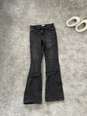 Svarta bootcut jeans - Snygga svarta bootcut jeans med utsvängda ben och klassisk femficksmodell. Jeansen har normal midja och dragkedja med knapp framtill. Den är i storlek 170 men skulle säga att dem är mer som S/XS.