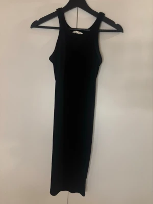 Svart ribbad långklänning H&M - Svart långklänning från H&M i ribbad bomull. Klänningen har en enkel, ärmlös design med rund halsringning och smal passform som framhäver siluetten. Använt ett antal gånger💕