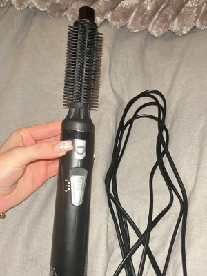 Svart varmluftsborste från OBH Nordica - Svart varmluftsborste från OBH Nordica med lång sladd och borsthuvud i plast. Borsten är 20 mm i diameter och är roterande för att försäkra att lockarna håller formen när de lossas från borsten. Air Curler har 2 hastigheter och 2 värmelägen och passar för användning i både torrt och fuktigt hår. Varmluftsborsten har en 2,8 m lång och vridbar sladd. använd få gånger, nästan som ny.  