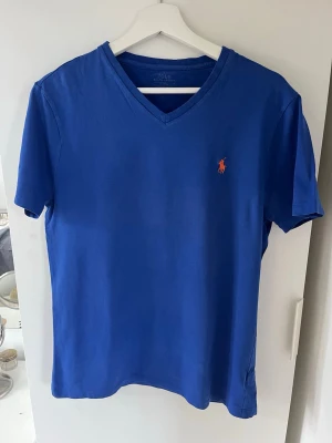 Blå v-ringad t-shirt från Polo Ralph Lauren - Snygg blå t-shirt från Polo Ralph Lauren.
