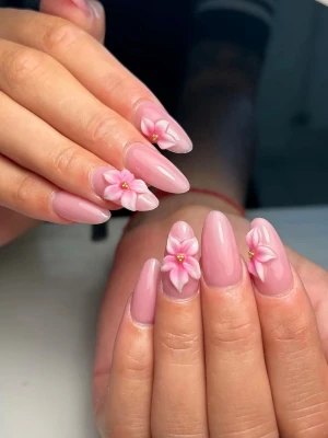 Rosa nageldekorationer med 3D-blommor - Nageldekorationer i ljusrosa med 3D-blommor och små gulddetaljer i mitten. Designen har en mandelformad stil och passar perfekt för dig som vill ha en söt och trendig look. 