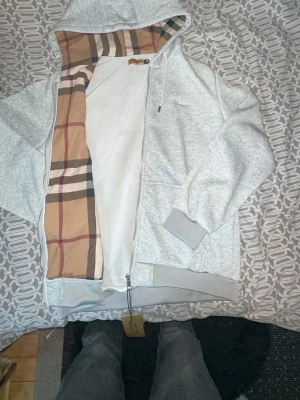 Bb hoodie  - En helt ny grå burberry hoodie. Den har en innre ficka vid högra sidan. Den är perfekt för året runt. Det står 2xl men är egentligen L. Den passar om man är 180+. Priset kan diskuteras 