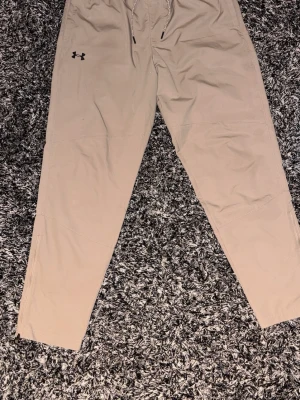 Beige träningsbyxor från Under Armour - ⚠️Där finns typ 2-3 jätte små fläckar på högra benet men de syns inte så⚠️ Annars är dom hur fina som helst nästan helt oanvända.