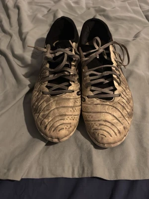 Nike Tiempo fotbollsskor beige/svart - Säljer ett par Nike Tiempo fotbollsskor i beige med svarta detaljer och snörning. Skorna har en låg profil och är tillverkade i syntetmaterial med klassisk Nike-logga på sidan. Perfekta för dig som vill ha stilrena och bekväma skor på planen. Pros, tvättar dem innan jag skickar!