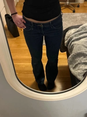 Mörkblå bootcut jeans - Snygga mörkblå bootcut jeans med klassisk femficksdesign och låg midja. Jeansen har raka ben med lätt utsvängning och är tillverkade i denim. Perfekta för en avslappnad och trendig look. Dem är omsydda från skinny till bootcut passform vilket ger en cool och diskret detalj på insidan av smalbenen. Säljer då de tyvärr blivit något små på mig och skulle säga att de passar någon som är runt 160 lång💕