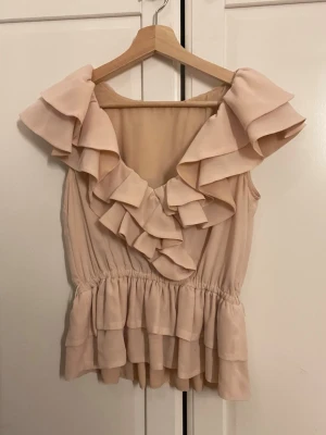 Rosa volangtopp - Supersöt rosa topp från hm som inte har lapp men är i stl 34 typ xs-s passar den och bilden är tagit i lite dåligt ljus men ser ut som andra bilden på 