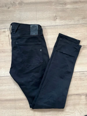 Svarta Replay Hyperflex jeans - Säljer ett par svarta Replay Hyperflex jeans i modellen Anbass. Jeansen har smal passform, klassiska fem fickor och stretchigt material för extra komfort. Perfekta för dig som gillar stilrena och bekväma jeans med modern look.(Priset är ej hugget i sten)🤩
