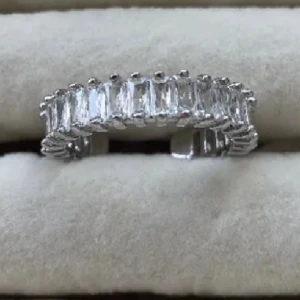 Silverfärgad ring med rektangulära stenar - Elegant silverfärgad ring prydd med rektangulära, glittrande stenar runt hela bandet. Perfekt för att ge en lyxig touch till din stil.