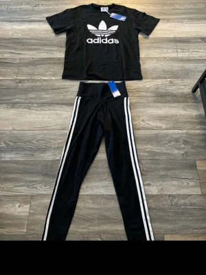 Svart Adidas set med t-shirt och tights - Snyggt svart Adidas set med t-shirt och tights. T-shirt storlek. S   leggings storlek XS 