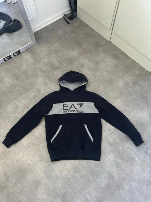 Emporio Armani hoodie - Stillren Emporio Armani hoodie med snygg logga på framsidan. Storlek L men går mer mot M hållet.