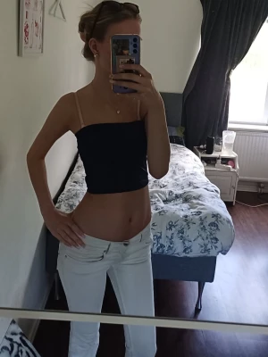 Mörkblå topp utan ärmar  - Säljer en mörkblå topp utan  axelband. Toppen är croppad och har en enkel, stilren design som passar perfekt till jeans eller kjol. Materialet känns mjukt och stretchigt, vilket gör den bekväm att bära under varma dagar.