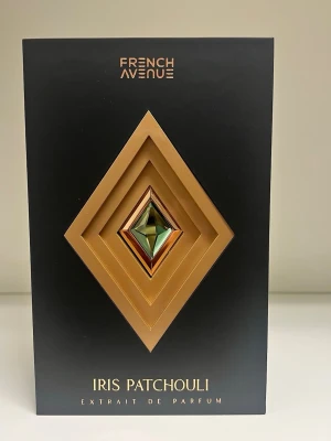 French Avenue Iris Patchouli Parfym 80 ml - Lyxig parfym från French Avenue, Iris Patchouli. Flaskan är svart med geometriska former i guld och en grön detalj i mitten. Snygg och modern design med exklusiv känsla. Kommer i en elegant svart och guld förpackning.Endast testad några spray (ca 4 spray).