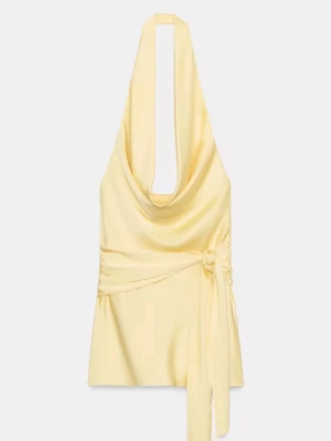 Slutsåld Zara satin klänning med skärp  - Superfin ljusgul halterneck klänning i satin med omlottknytning i midjan. Klänningen har en snygg draperad urringning och öppen rygg, perfekt för varma dagar. Materialet är glansigt och ger en lyxig känsla. Aldrig använd prisslapp finns kvar. 
