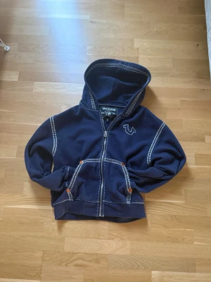 Mörkblå true religion Zip Hoodie - En mörkblå Zip hoodie från True religion sitter jätte skönt och snyggt på. Andvänts fåtal gånger. NY PRIS 1600