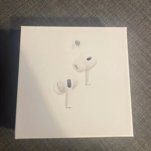 AirPods Pro (2nd generation) with MagSafe Charging Case (USB-C) - Säljer ett par AirPods Pro 2 med MagSafe-laddningsetui (USB-C). Produkten är i originalförpackning endast testade ett fåtal gånger. Aktiv brusreducering, transparensläge och hög ljudkvalitet. Perfekt för både musik och samtal. Kartongen har mindre märken men hörlurarna är i nyskick. Är osäker på äktheten då jag fick de, men inget kvitto.