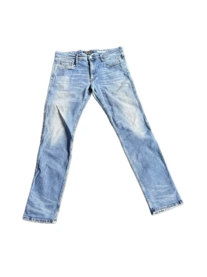 Blå jeans från Replay  - Snygga blå slim fit jeans med lätt slitna detaljer och klassisk femficksdesign. Jeansen har normal midja, dragkedjegylf och raka ben. Perfekta för en avslappnad och trendig look.