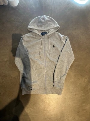 Grå hoodie med luva - Snygg grå hoodie med luva. Perfekt för en avslappnad och stilren look. Mjuk bomullsblandning som känns skön mot huden. Använd några gånger med försiktigthet men annars helt ny. Priset kan diskuteras. Hör av er vid frågor!😊