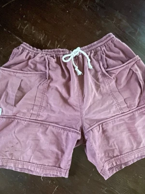 Coola retro shorts - Rostfärgade. Loose passform och är tillverkade i mjuk bomull, perfekta för varma dagar. Stora bakfickor med knappdetalj ger en cool touch. ~L