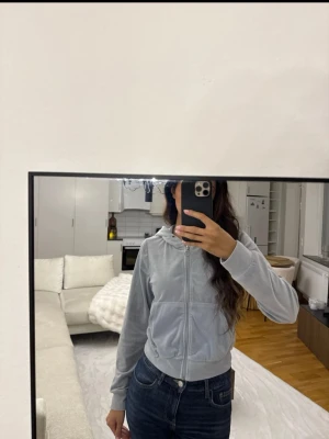 Ljusgrå zip-hoodie med huva - Snygg ljusgrå hoodie med dragkedja och huva. Modellen har fickor framtill och ribbade muddar vid ärmslut och midja. Perfekt för en avslappnad och trendig stil. Materialet är mjukt och bekvämt i sammet.