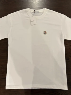White t-shirt with logo  - A plain white t-shirt with a colored logo in the size M