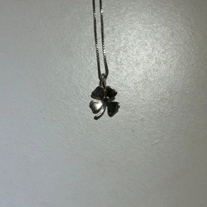Silverhalsband med fyrklöverberlock i äkta silver - Silverhalsband med en fyrklöverberlock i äkta silver. Kedjan är tunn och smidig (ej säker på om den också är äkta silver), vilket gör den bekväm att bära varje dag.