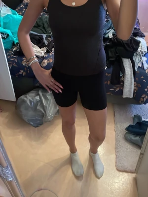 Mörk grå tajt sport linne - Säljer ett linne med tight passform. De är gjorda i ett stretchigt syntetmaterial som sitter skönt mot kroppen och passar perfekt till träning eller en sportig look. 