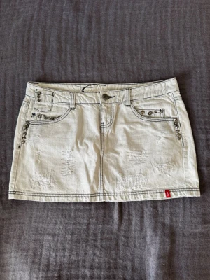Lågmidjad jeanskjol - Säljer den här lågmidjade jeanskjol från EDC by Esprit i vitt/ljusgrått. Den är vintage, unik och snygg samt så sitter den lite oversized på mig som vanligtvis har M/38. Kjolen är i L/40. Skriv för mått!